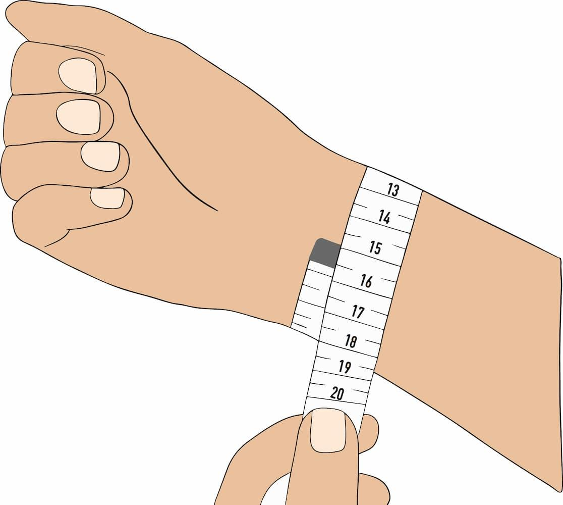 A soft measuring tape wrapped around a wrist just below the wrist bone, showing how to read the wrist circumference